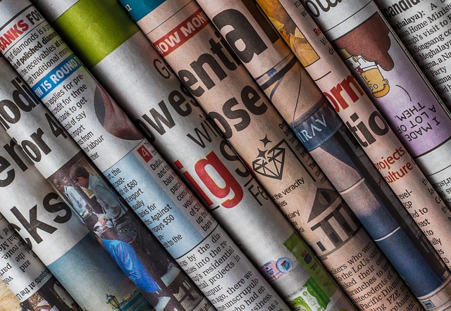 Rolled newspapers arranged in a vertical line display headlines and images, resembling the structured art of HARO link building. Text and graphics in various colors showcase typical newspaper layouts with headlines, articles, and pictures.