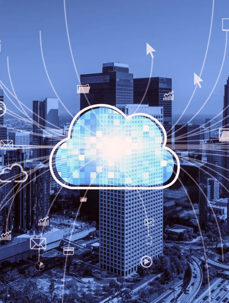 A digital illustration of a cloud overlaid on a cityscape, symbolizing cloud computing. The cloud is connected to various icons like arrows and envelopes, representing data and communication pathways. The background features tall buildings under a blue sky.
