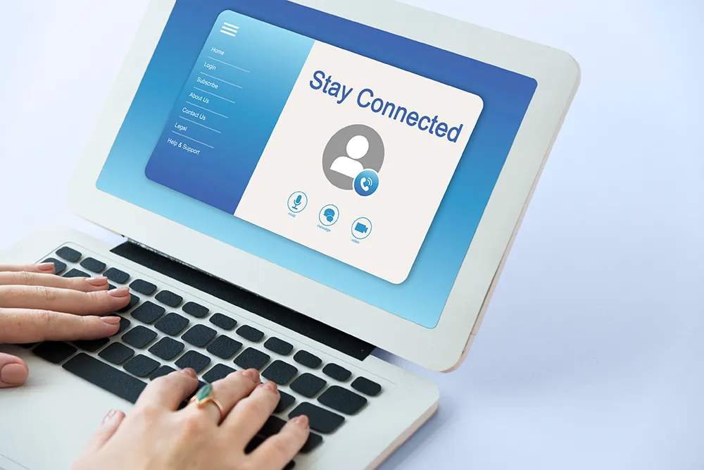 Hands are typing on a laptop keyboard. The screen displays a "Stay Connected" message with a user icon and communication symbols, set against a blue gradient background.